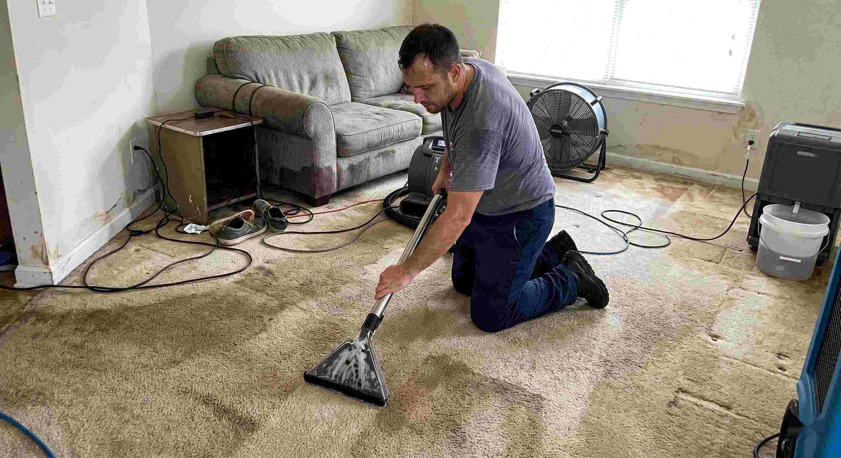 Reliable technician performing carpet water extraction in a residential home using professional equipment after water damage in Boca Raton