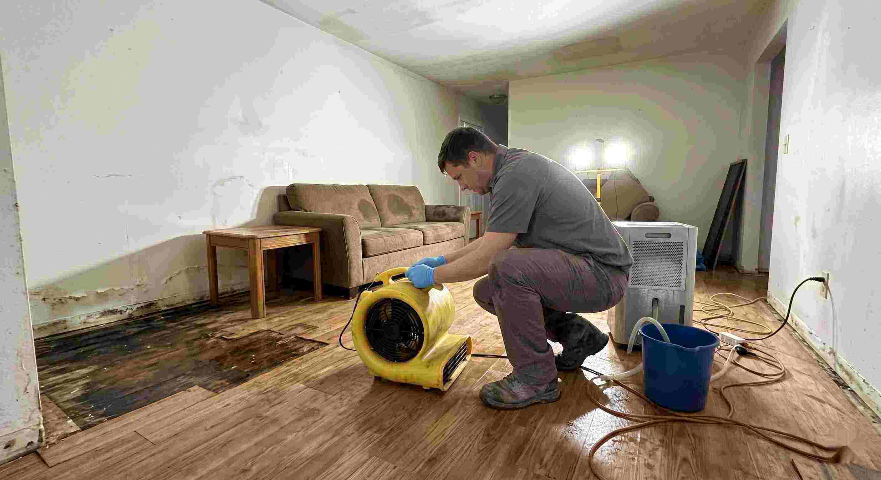 Reliable water damage restoration technician drying wet floors with equipment during cleanup process in Pembroke Pines
